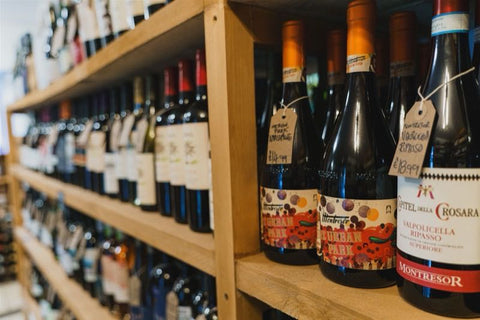 Wine bottles on a wooden shelf in a store